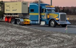 Industrial Generators in Long Island: Long Island Power Systems Keeps Your Business Running Smoothly | 9 | Long Island Power Systems Blue and yellow Peterbilt semi-truck hauling a Kohler generator on a flatbed trailer.
