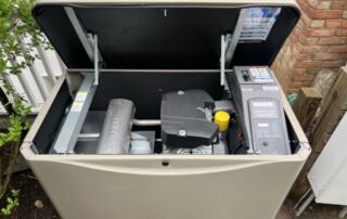 Generator Maintenance Documentation: Why Service Records Matter More Than You Think | 3 | Long Island Power Systems Open Kohler standby generator installed outdoors beside a house, showing internal engine components during inspection or maintenance.